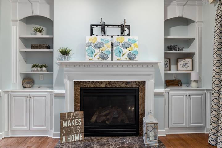 Fireplace with a pale mantel, stone surround and built-in shelves